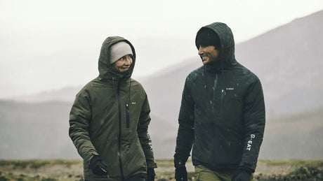 meilleurs gants chauffants portés par deux randonneurs sous la pluie en montagne